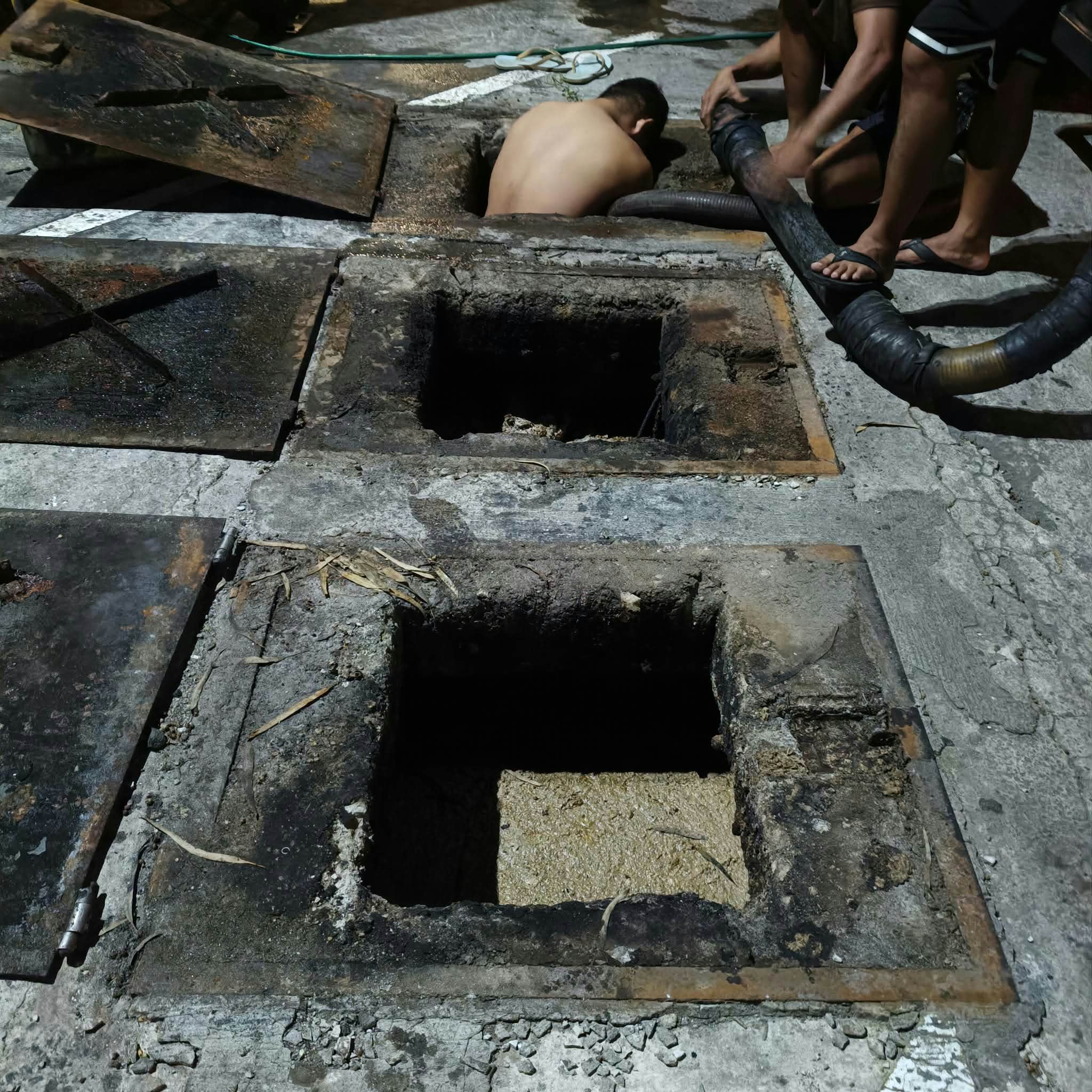Crew member performing septic tank maintenance